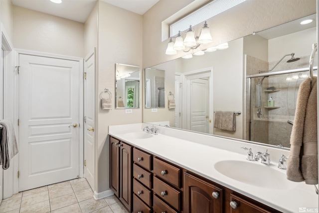 bathroom with a stall shower, double vanity, and tile patterned flooring