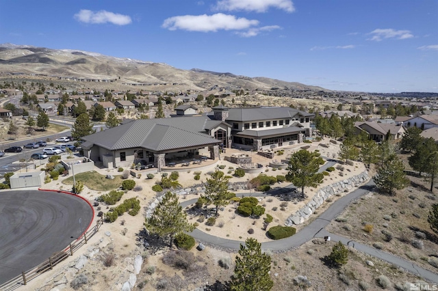 aerial overview of property's location with a mountainous background and nearby suburban area