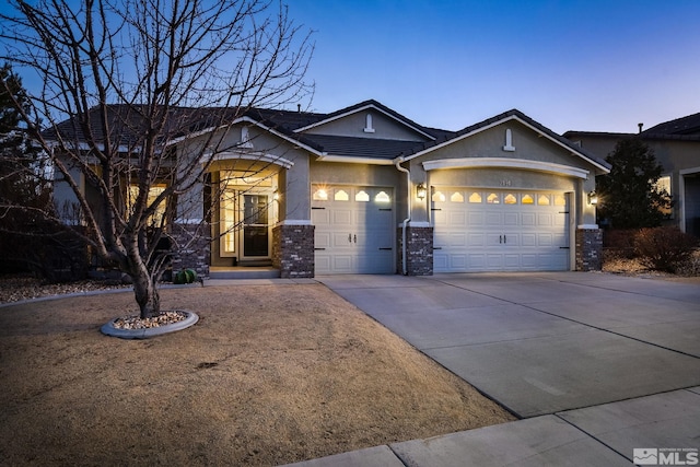 2191 Talladega Ct, Sparks, NV 89436 - view of front of house featuring a garage, concrete driveway, stucco siding, and stone siding