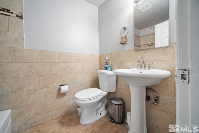 1672 Sue Way, Sparks, NV 89431 - bathroom with tile walls, toilet, wood finished floors, a wainscoted wall, and a sink