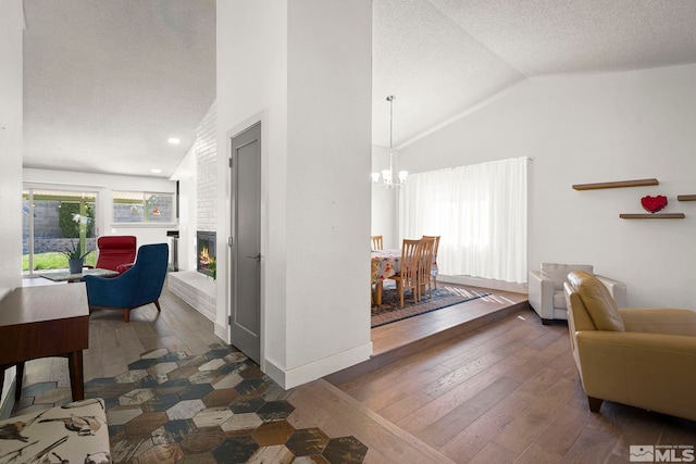 920 Pinebrook Rd, Reno, NV 89509 - living area featuring a chandelier, vaulted ceiling, hardwood / wood-style flooring, a textured ceiling, and a fireplace