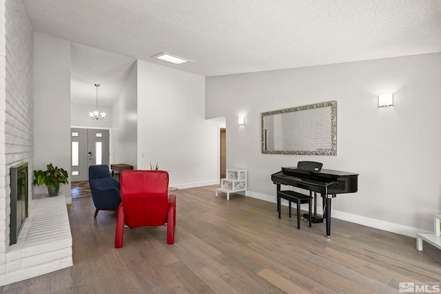 920 Pinebrook Rd, Reno, NV 89509 - living area with wood finished floors, high vaulted ceiling, a fireplace, a textured ceiling, and a chandelier