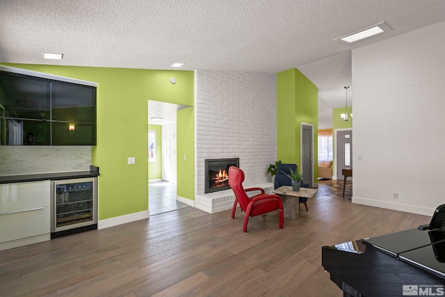 920 Pinebrook Rd, Reno, NV 89509 - living room with wine cooler, a textured ceiling, wood finished floors, high vaulted ceiling, and a brick fireplace