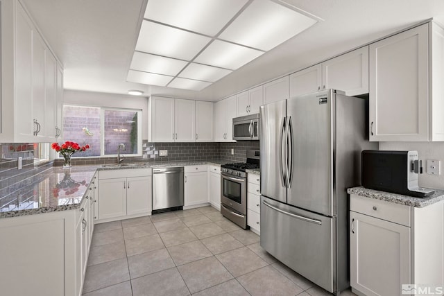 920 Pinebrook Rd, Reno, NV 89509 - kitchen with stainless steel appliances, a sink, white cabinetry, light tile patterned floors, and light stone counters