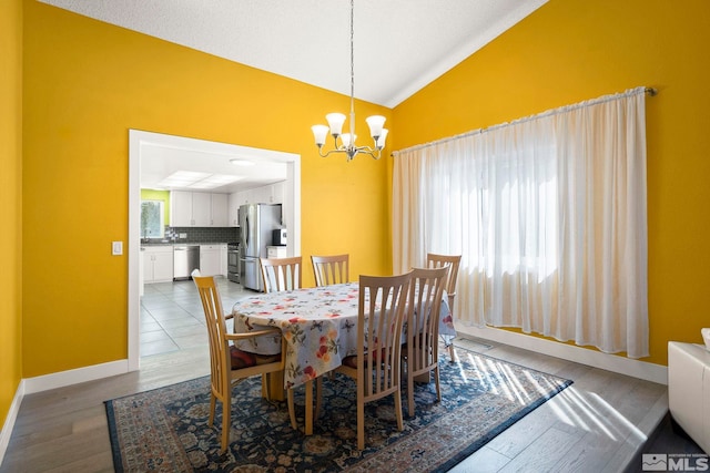 920 Pinebrook Rd, Reno, NV 89509 - dining space featuring lofted ceiling, a chandelier, light wood-style floors, and baseboards