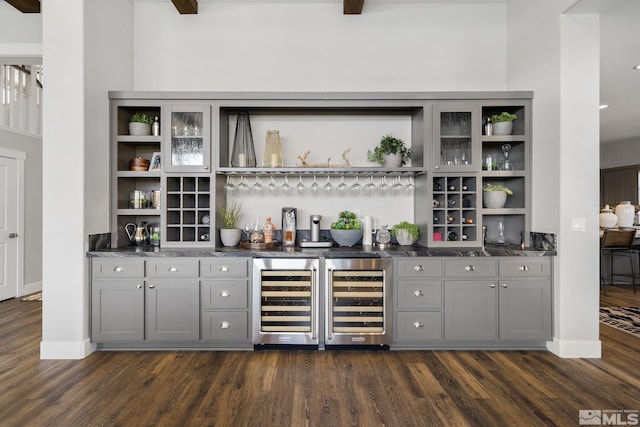 indoor wet bar featuring wine cooler, dark wood-style floors, and baseboards