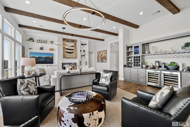 living room featuring beverage cooler, beam ceiling, dark wood-style flooring, bar, and a fireplace