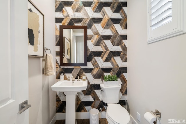 bathroom featuring toilet, tasteful backsplash, and a sink