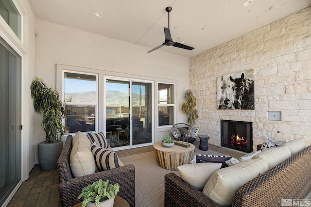 living area featuring a ceiling fan, a stone fireplace, and recessed lighting