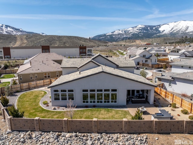 rear view of property featuring a mountain view, a fenced backyard, a patio, and a residential view