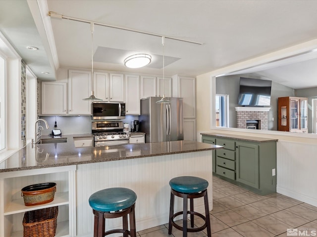 286 Woodlake Cir, Dayton, NV 89403 - kitchen with stainless steel appliances, a sink, a peninsula, open shelves, and a breakfast bar
