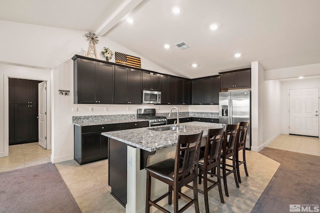 1981 Lanstar Dr, Sparks, NV 89441 - kitchen featuring stainless steel appliances, light tile patterned floors, light stone counters, a sink, and a kitchen bar