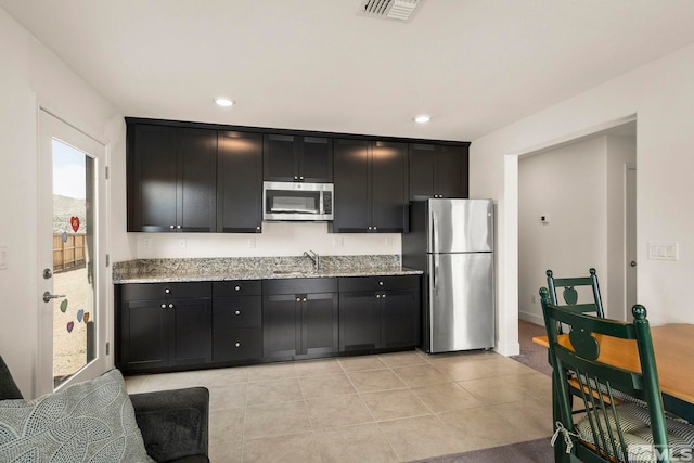 1981 Lanstar Dr, Sparks, NV 89441 - kitchen featuring stainless steel appliances, a sink, dark cabinetry, light stone counters, and recessed lighting