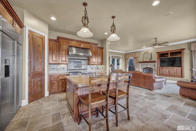 5140 Belsera Ct, Reno, NV 89519 - kitchen featuring built in fridge, under cabinet range hood, stone tile floors, ceiling fan, and open floor plan