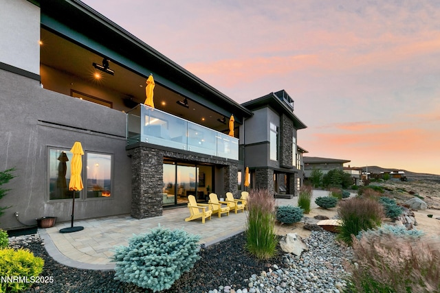 6372 Mormon Tea Way, Reno, NV 89511 - back of house with a balcony, a patio area, stucco siding, stone siding, and a chimney