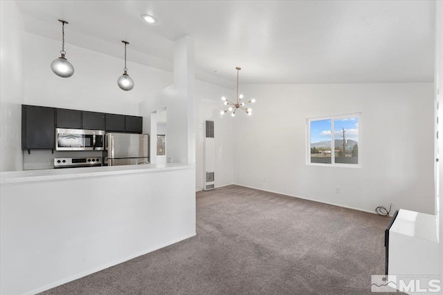 490 Highland Ave Unit 16, Reno, NV 89512 - kitchen featuring appliances with stainless steel finishes, carpet floors, dark cabinets, a chandelier, and pendant lighting