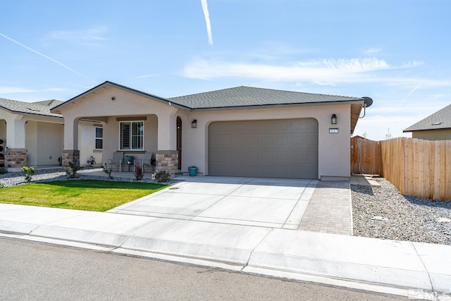 1117 Dapple Dr, Minden, NV 89423 - view of front facade featuring fence, stucco siding, a garage, concrete driveway, and a porch