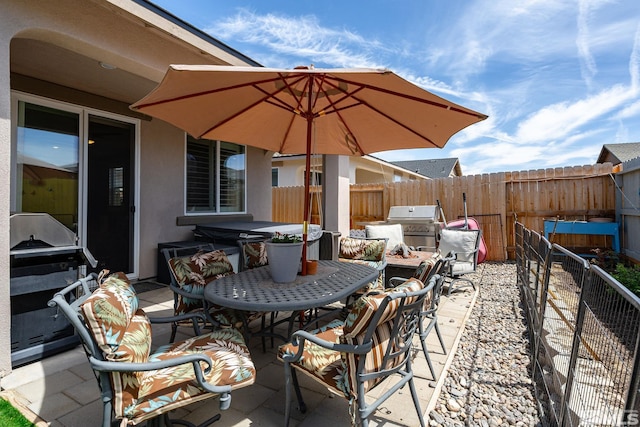 1117 Dapple Dr, Minden, NV 89423 - view of patio / terrace featuring a hot tub, a fenced backyard, outdoor dining space, and a grill