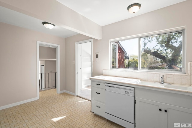 1100 Keystone Ave, Reno, NV 89503 - kitchen featuring dishwasher, baseboards, white cabinetry, a sink, and tasteful backsplash