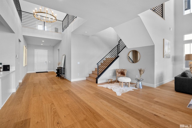 5424 Side Saddle Trl, Reno, NV 89511 - foyer with a towering ceiling, stairway, a chandelier, light wood finished floors, and baseboards
