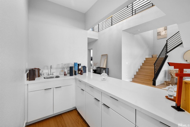 5424 Side Saddle Trl, Reno, NV 89511 - bar area with a sink, a towering ceiling, stairway, and light wood finished floors