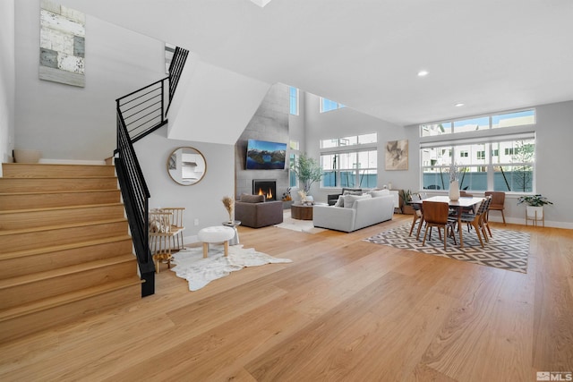 5424 Side Saddle Trl, Reno, NV 89511 - living room featuring stairs, a high ceiling, plenty of natural light, light wood-style flooring, and baseboards