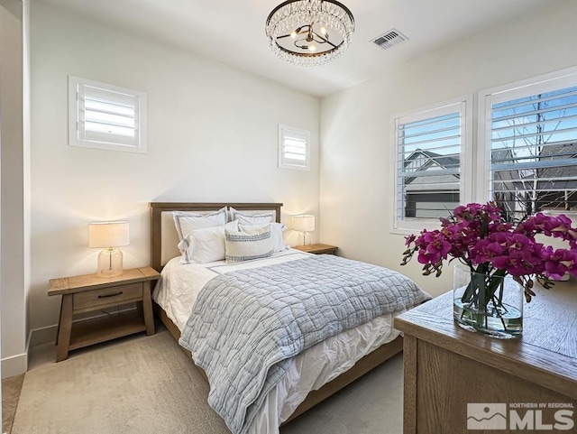 bedroom with a chandelier and light colored carpet