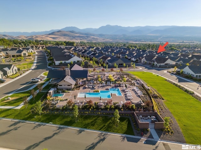 aerial view of residential area with a pool and a mountainous background