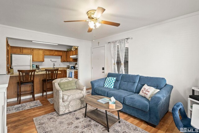 1465 E Peckham Ln Unit 9, Reno, NV 89502 - living room featuring ceiling fan, light wood finished floors, and crown molding