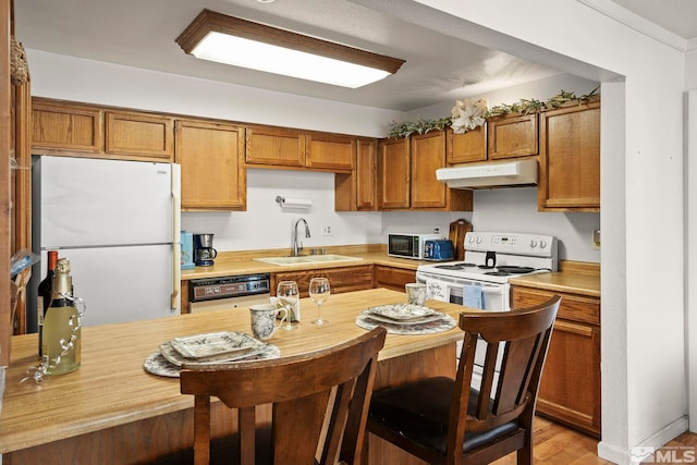 1465 E Peckham Ln Unit 9, Reno, NV 89502 - kitchen featuring white appliances, a sink, under cabinet range hood, and light countertops