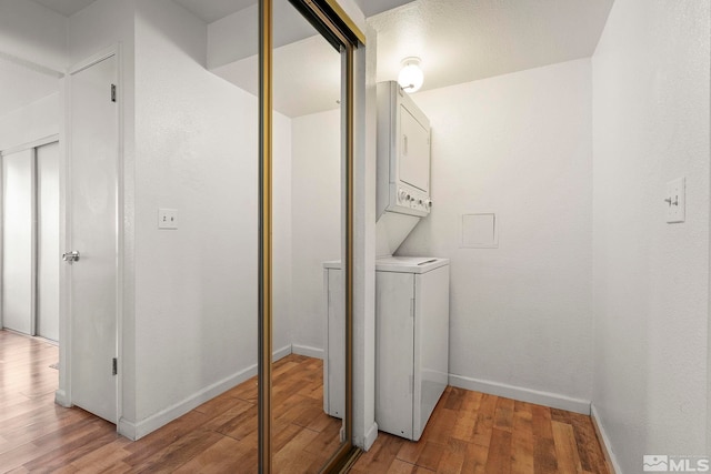 1465 E Peckham Ln Unit 9, Reno, NV 89502 - laundry room with stacked washer / dryer, light wood finished floors, and baseboards