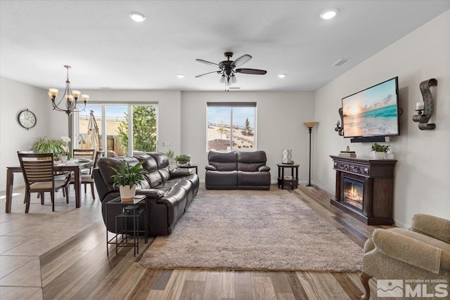 8555 Spearhead Way, Reno, NV 89506 - living area with a chandelier, ceiling fan, a glass covered fireplace, wood finished floors, and recessed lighting