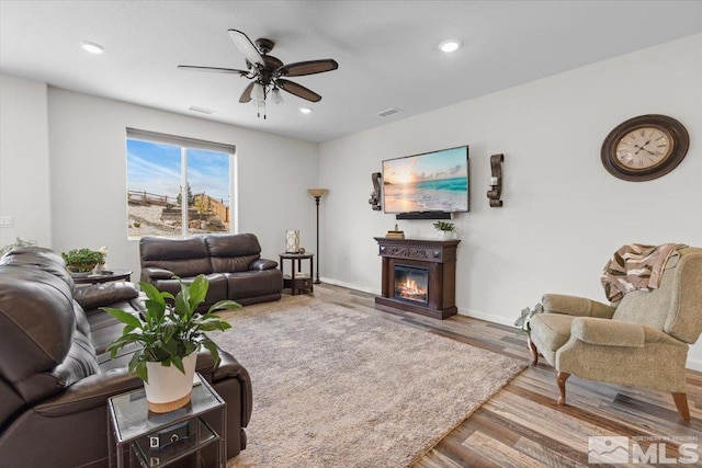 8555 Spearhead Way, Reno, NV 89506 - living area featuring ceiling fan, a glass covered fireplace, wood finished floors, recessed lighting, and baseboards