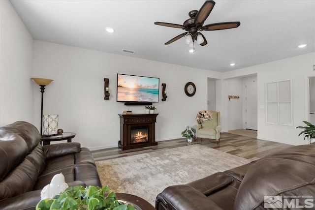 8555 Spearhead Way, Reno, NV 89506 - living area with wood finished floors, a ceiling fan, recessed lighting, a lit fireplace, and baseboards