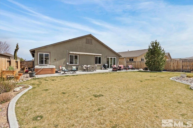 8555 Spearhead Way, Reno, NV 89506 - rear view of property featuring a hot tub, a patio area, and stucco siding