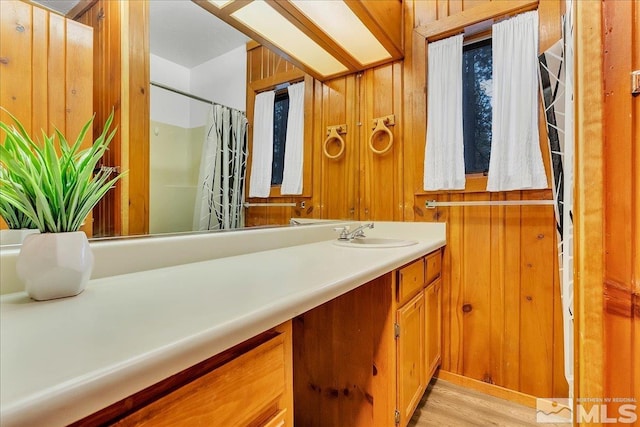 3628 Forest Ave, South Lake Tahoe, CA 96150 - bathroom featuring vanity, wooden walls, a shower with curtain, and wood finished floors