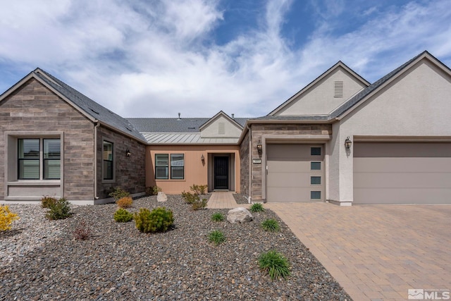 3019 Copper Stone Dr, Reno, NV 89521 - view of front of home featuring a standing seam roof, an attached garage, driveway, metal roof, and stone siding