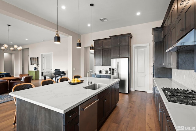 3019 Copper Stone Dr, Reno, NV 89521 - kitchen with a sink, appliances with stainless steel finishes, tasteful backsplash, a kitchen bar, and light stone counters