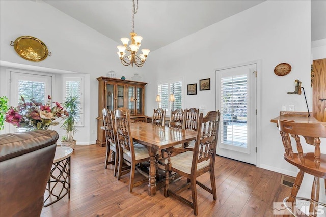 2875 Waegle Way, Fernley, NV 89408 - dining area with high vaulted ceiling, a chandelier, light wood-style floors, and baseboards
