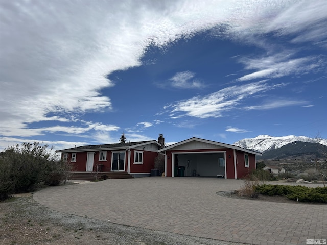 15900 Curtis Ln, Reno, NV 89511 - ranch-style home with decorative driveway, a mountain view, an attached garage, and a chimney
