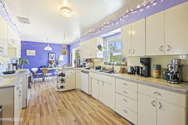 15900 Curtis Ln, Reno, NV 89511 - kitchen with white appliances, a sink, light wood finished floors, decorative backsplash, and a peninsula