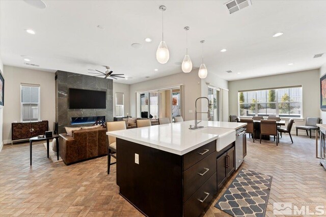 6103 S Pleasant Oak Trl, Reno, NV 89511 - kitchen featuring a sink, open floor plan, light countertops, a ceiling fan, and brick flooring
