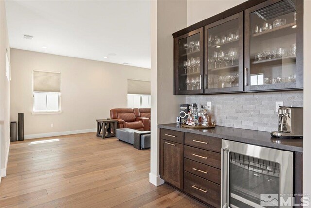 6103 S Pleasant Oak Trl, Reno, NV 89511 - indoor dry bar featuring wine cooler, backsplash, light wood finished floors, and baseboards