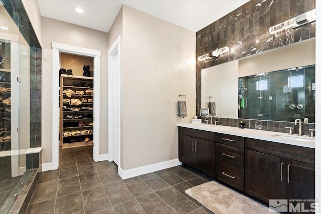 6103 S Pleasant Oak Trl, Reno, NV 89511 - full bathroom with a spacious closet, double vanity, a tile shower, baseboards, and recessed lighting