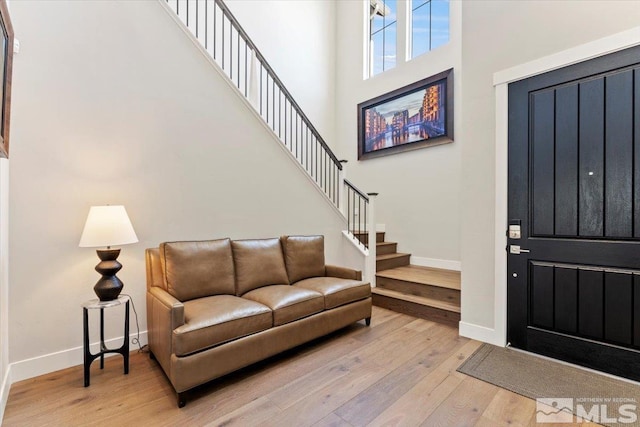 6103 S Pleasant Oak Trl, Reno, NV 89511 - foyer entrance with baseboards, stairway, light wood-type flooring, and a towering ceiling