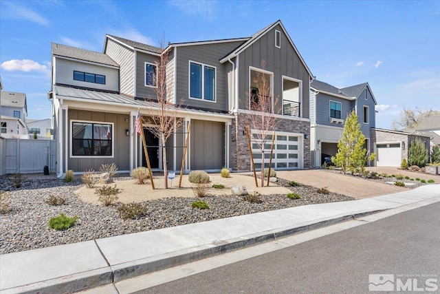 6103 S Pleasant Oak Trl, Reno, NV 89511 - view of front facade featuring board and batten siding, an attached garage, driveway, fence, and a residential view