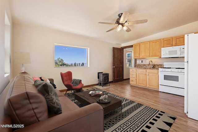 4775 Mount Rose Hwy, Reno, NV 89511 - living area featuring a wood stove, ceiling fan, light wood-style floors, lofted ceiling, and baseboards