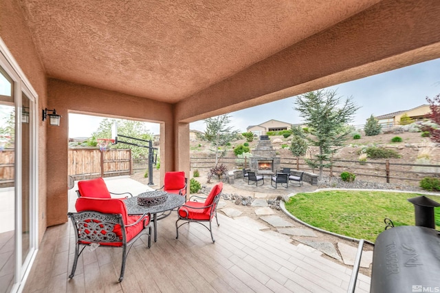 13335 Satinspar Dr, Reno, NV 89511 - wooden deck featuring an outdoor stone fireplace, a patio area, and a fenced backyard