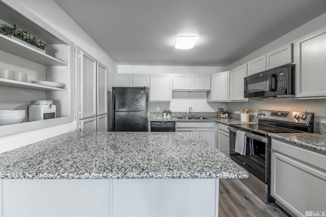 1465 E Peckham Ln Apt 20, Reno, NV 89502 - kitchen featuring black appliances, a sink, open shelves, light stone countertops, and dark wood finished floors