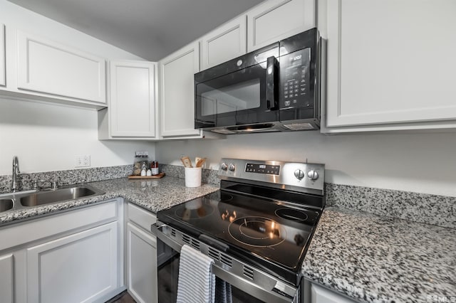 1465 E Peckham Ln Apt 20, Reno, NV 89502 - kitchen with electric stove, black microwave, a sink, white cabinets, and vaulted ceiling
